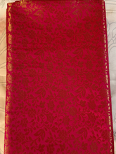 Red fabric with gold floral patterns on a white background