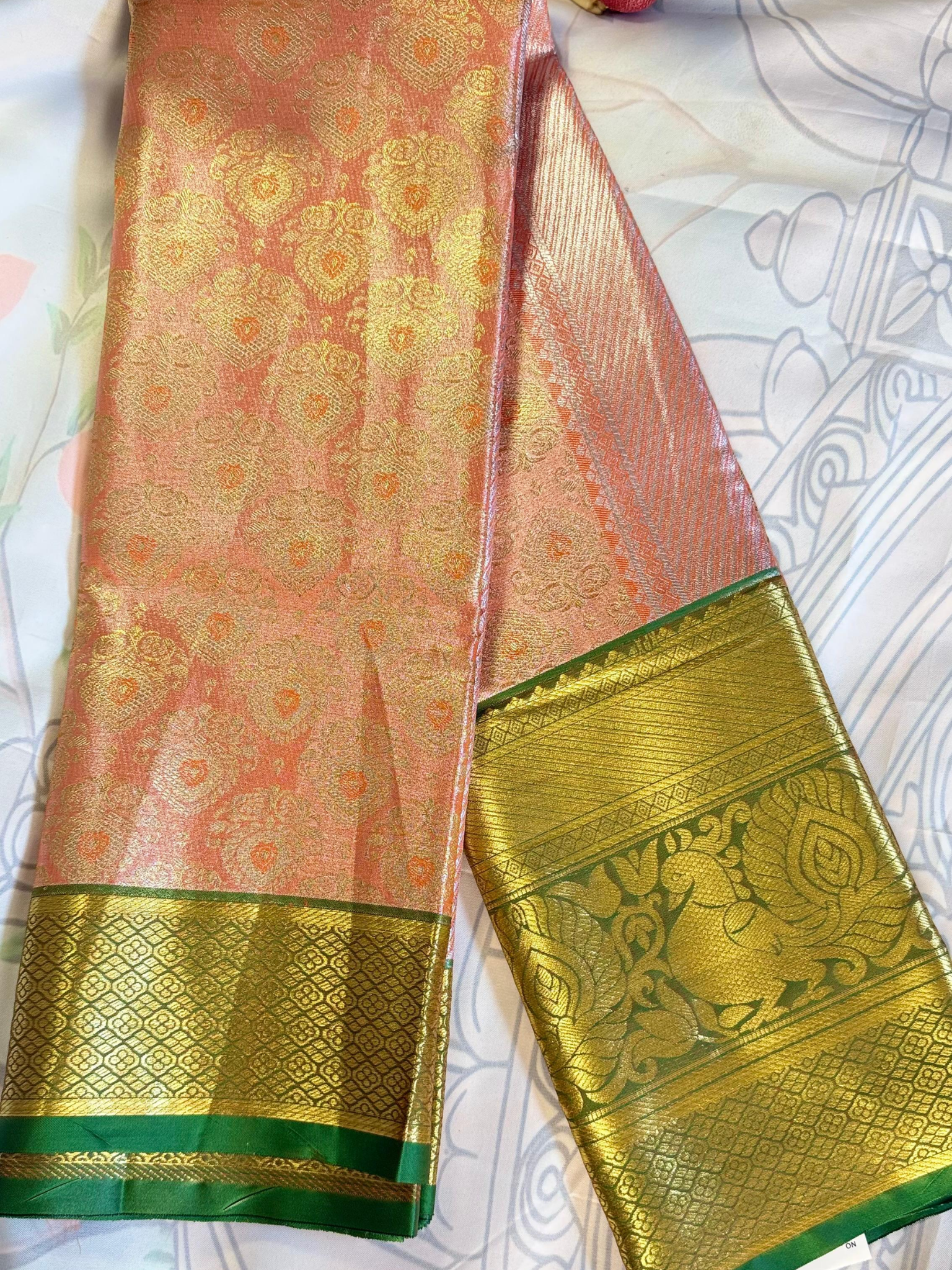 Traditional saree with pink and green patterns on a white background