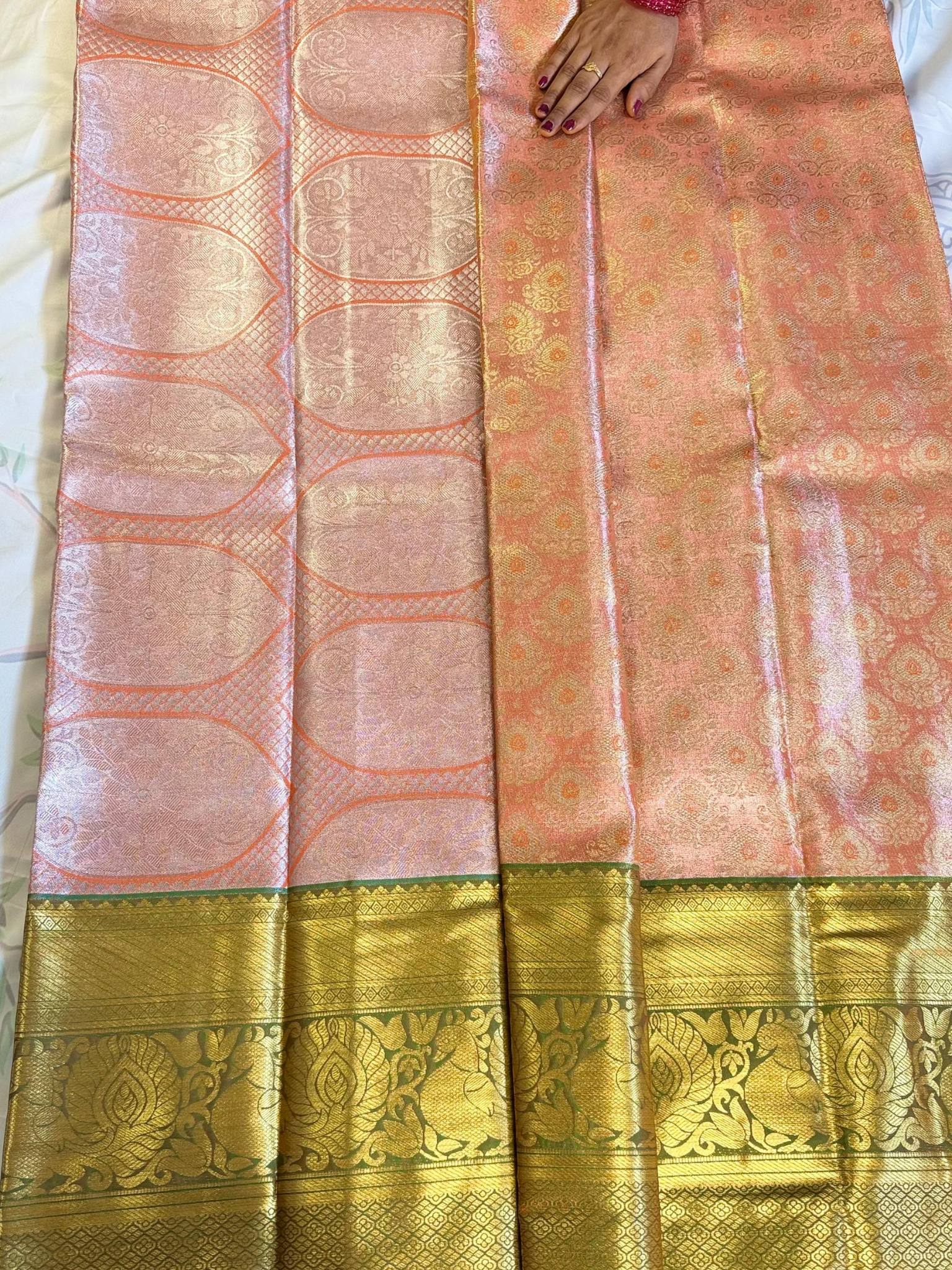 Traditional saree with gold and pink patterns on a plain background