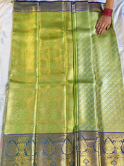 Green saree with gold and blue patterns on a white background