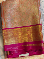 Gold and pink saree with intricate patterns on a plain background