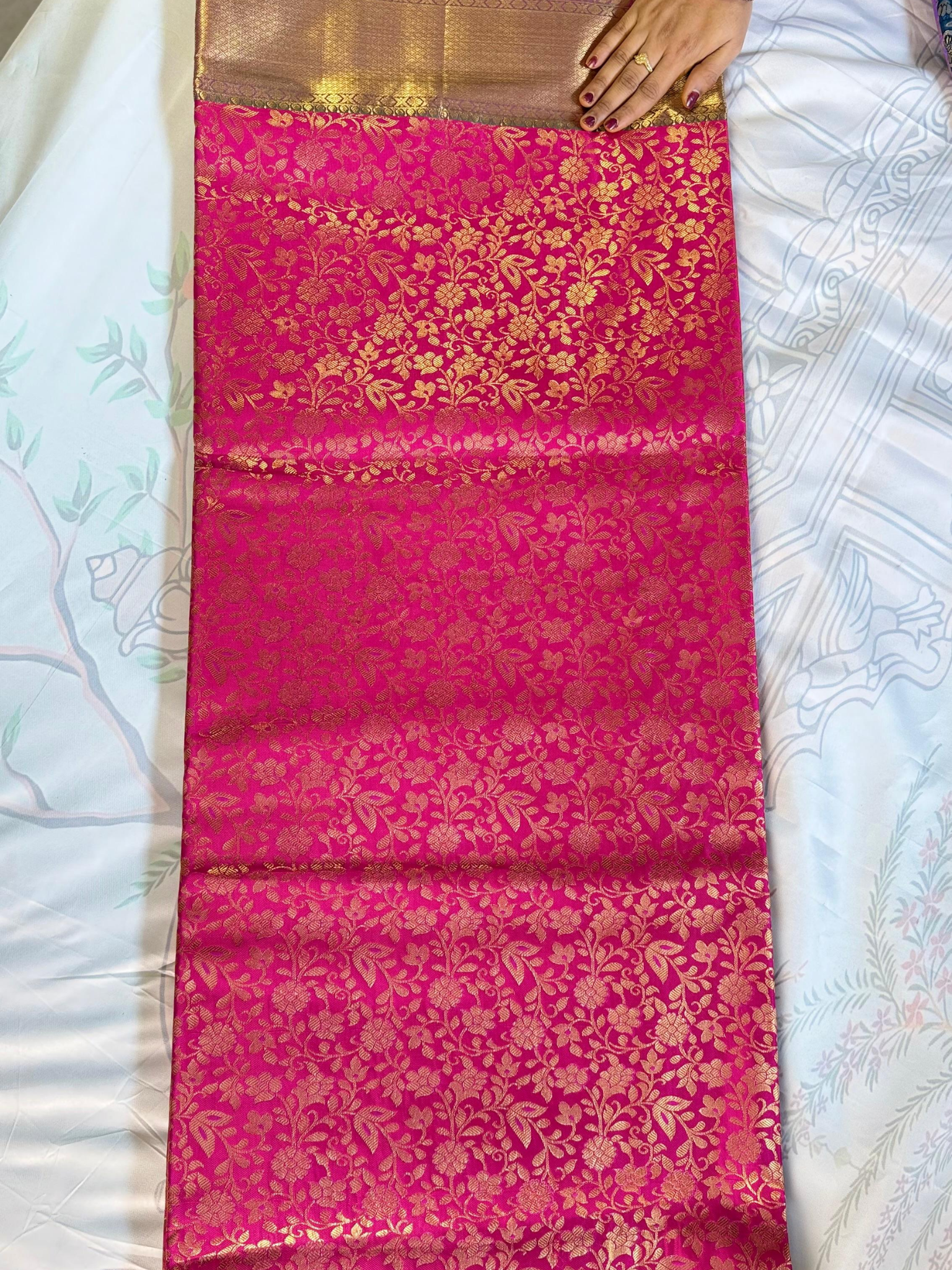 Pink saree with gold patterns on a white background