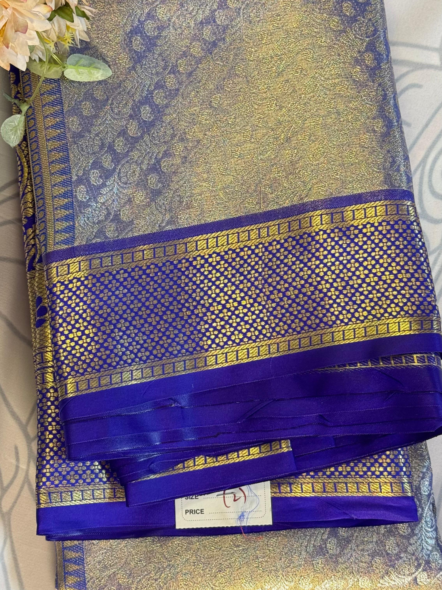Blue and gold saree with a visible brand label on a light background