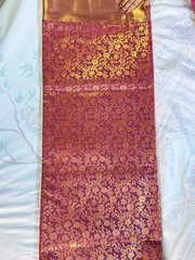 Red fabric with gold floral patterns on a white surface