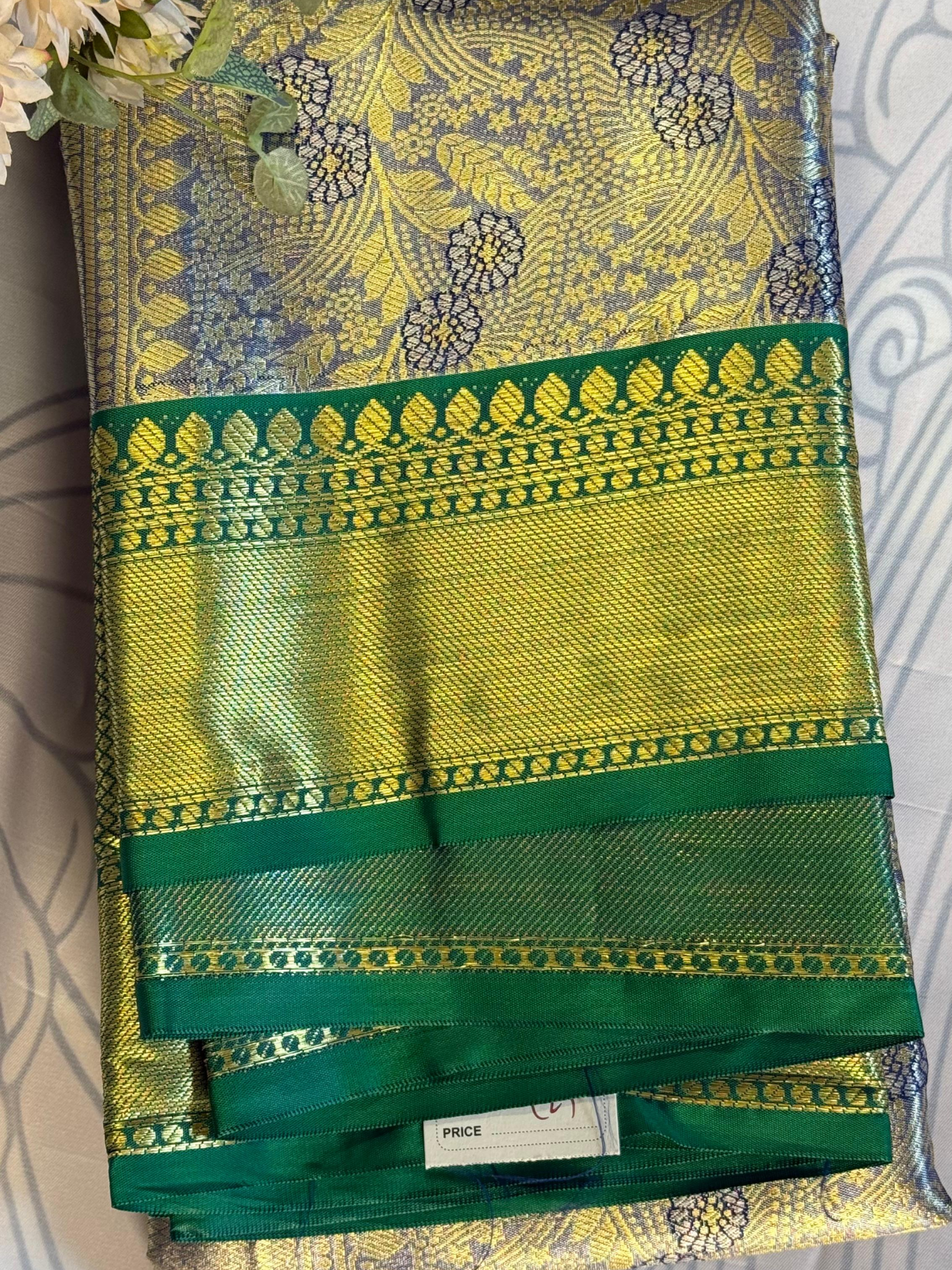 Green and yellow saree with floral patterns on a white background