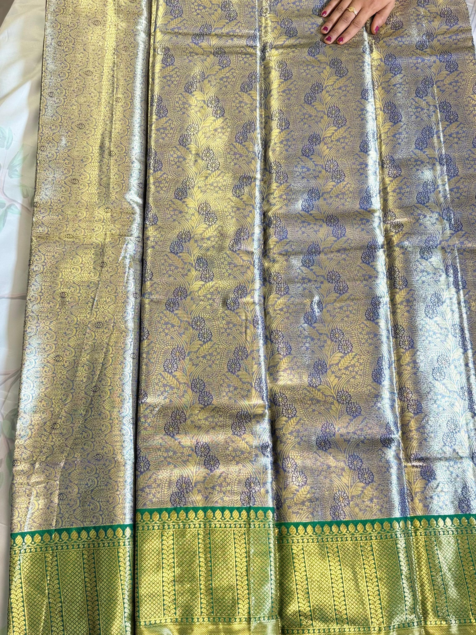 Traditional saree with a green border on a plain background