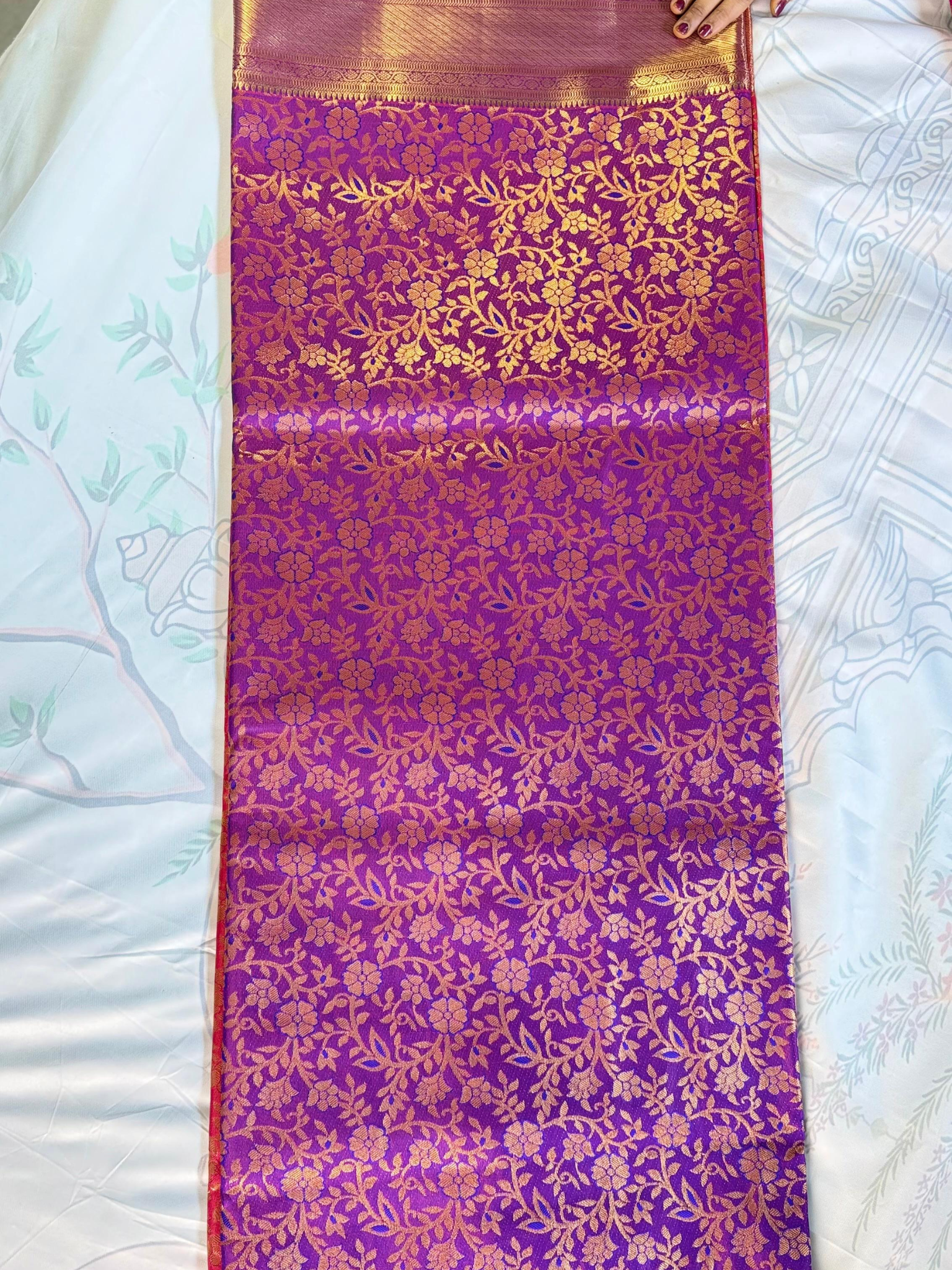 Purple fabric with gold floral patterns on a white surface