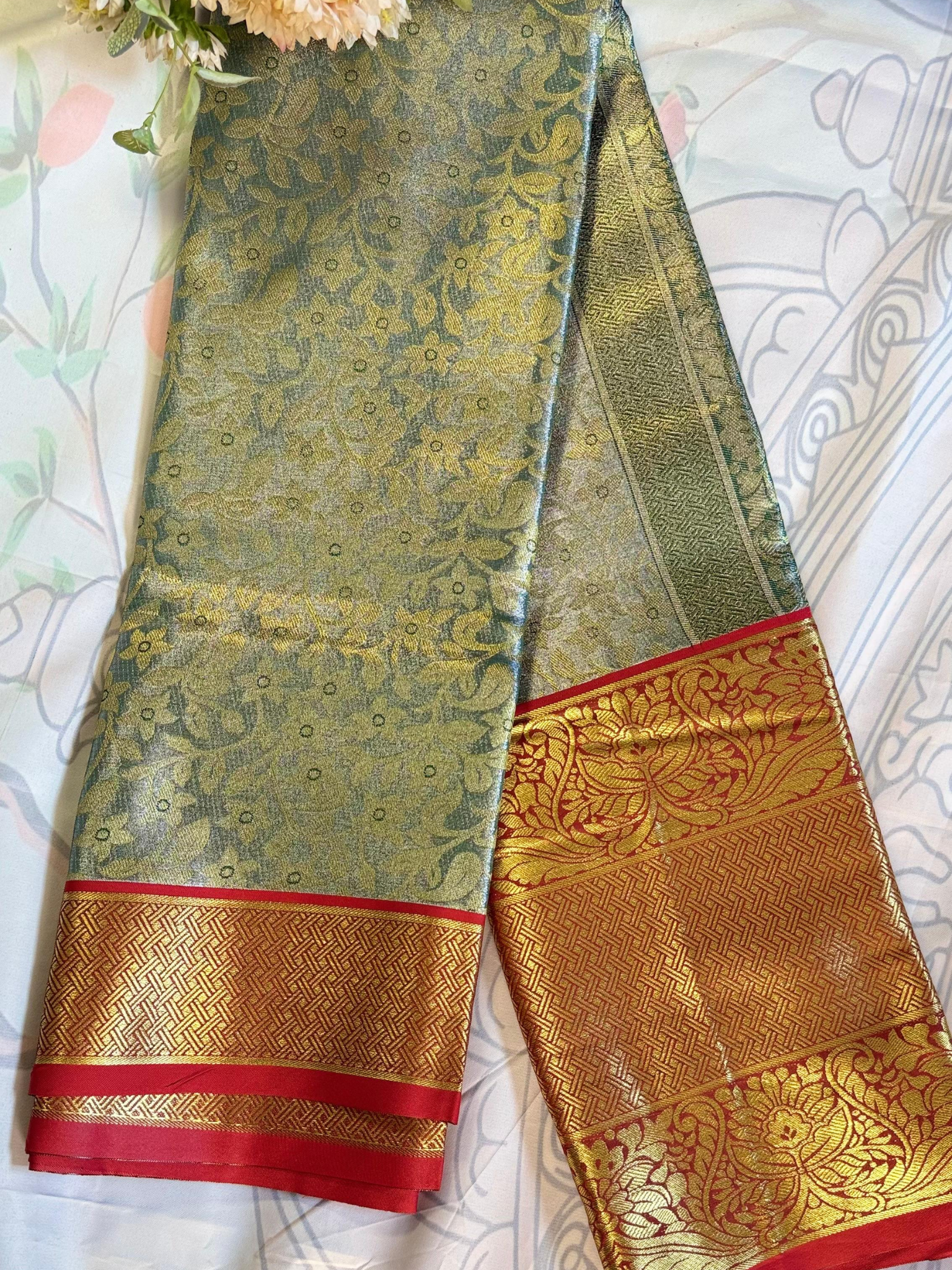 Traditional saree with gold and red border on a white background