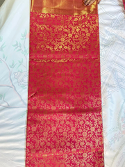 Red saree with gold floral patterns on a white background