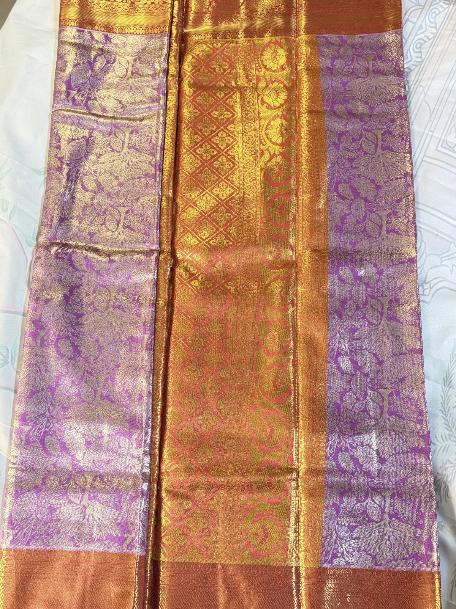 Saree with purple and gold patterns on a white background